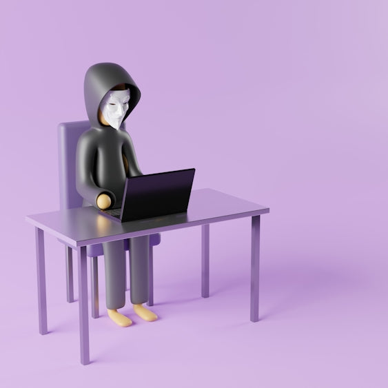 a person sitting at a desk with a laptop on it